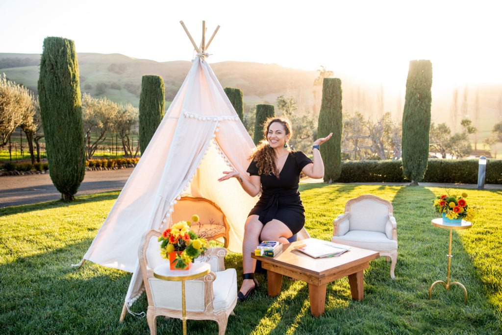 Samar Hattar Wedding Event Planner in California sit in front of a white TeePee.