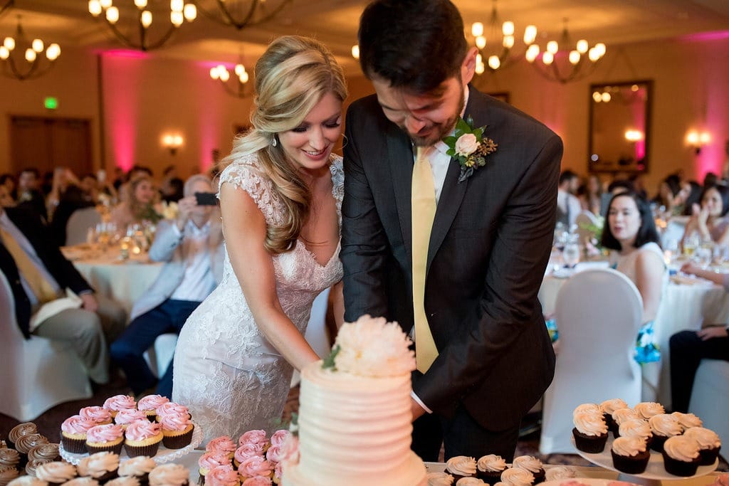 A bride and groom cut into a wedding cake at their northern California wedding. 