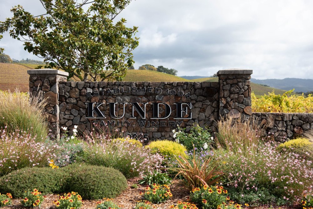 A stone wall shows the sign of the Kunde Family Winery wedding venue.