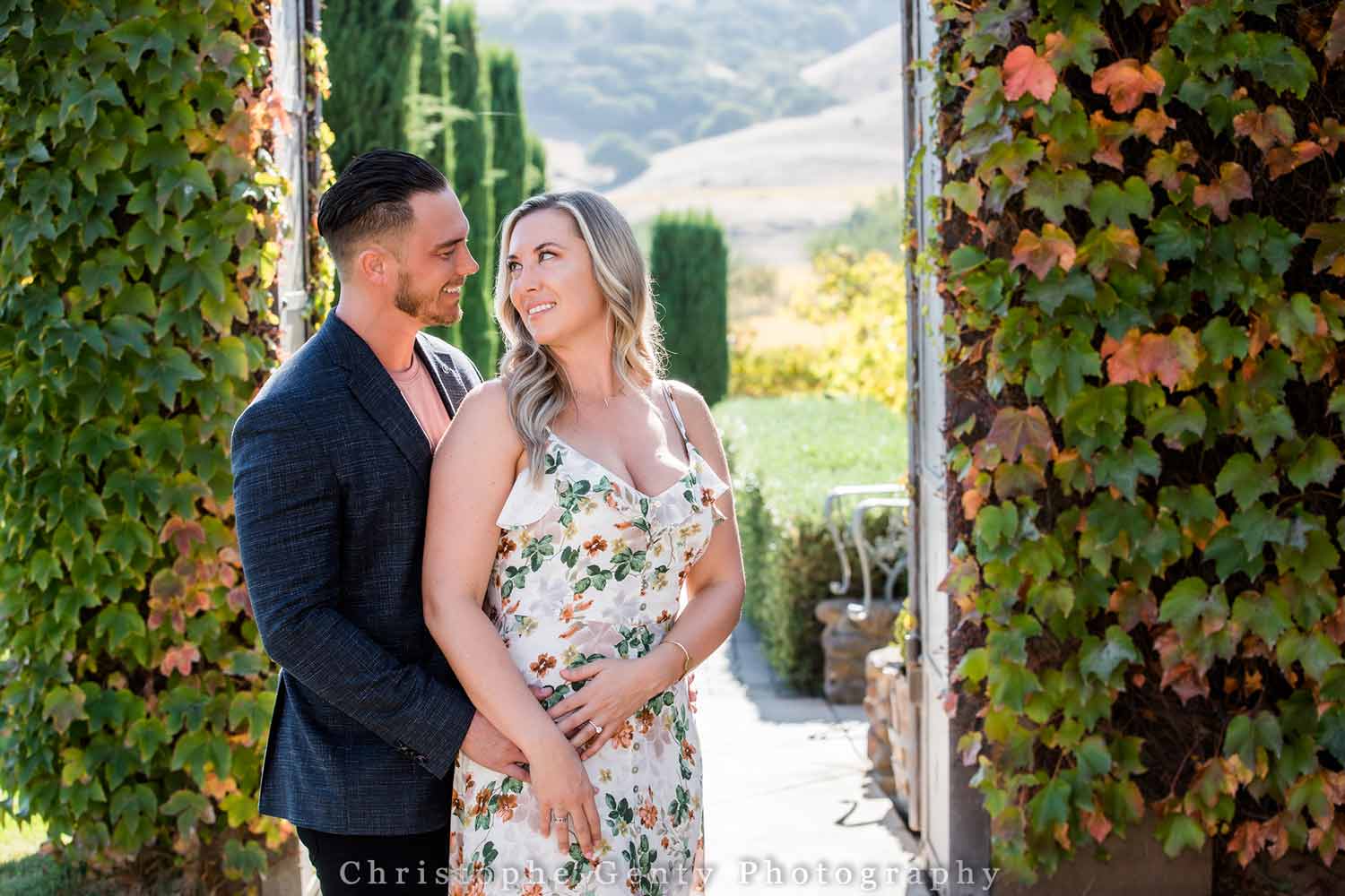 Newly engaged couple stands among vines at Viansa Winery.