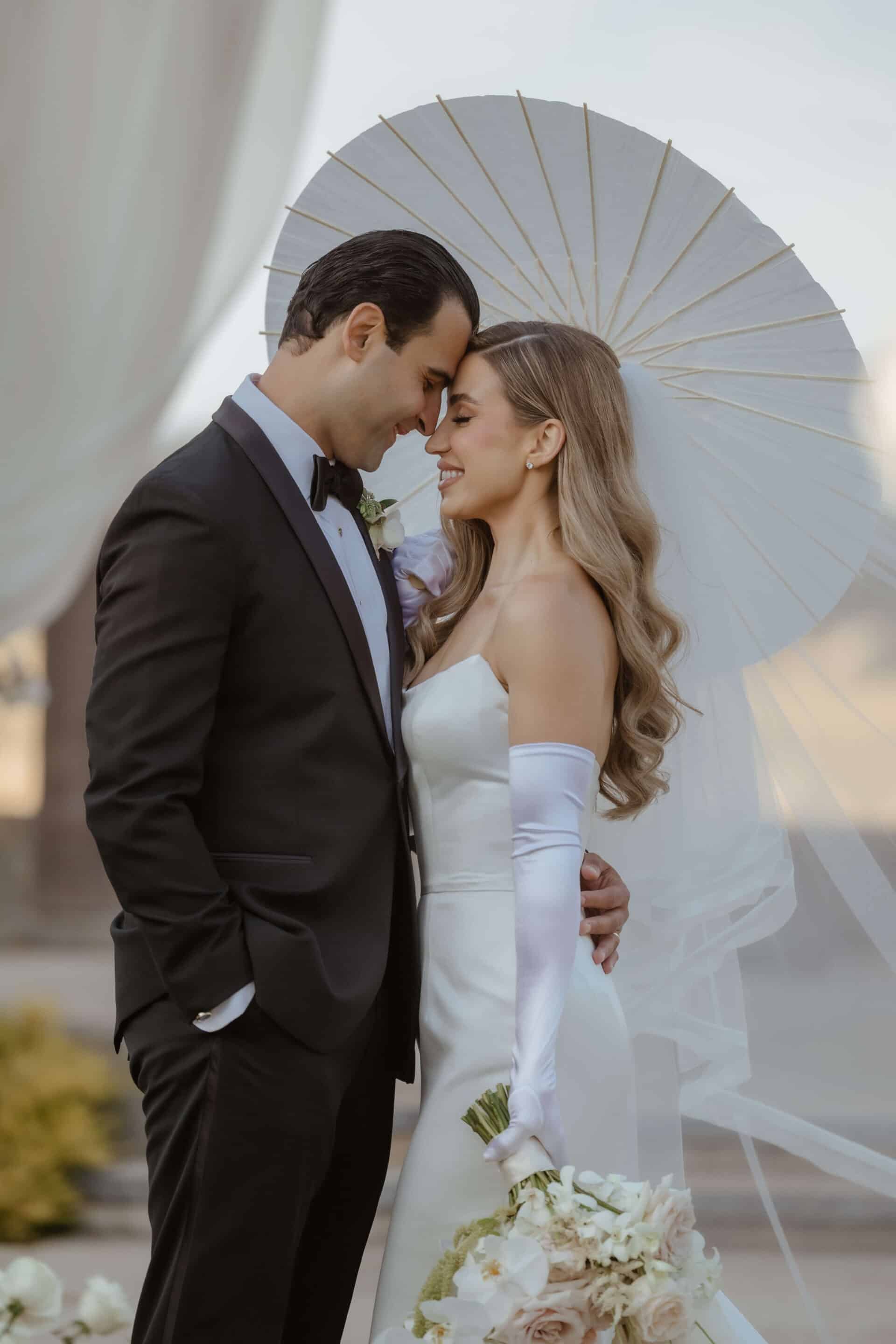 A bride and groom stand together. Flowers by Bella Vita Productions. Photo by Andrea Lowry Photography. Wedding by Blissful Events.